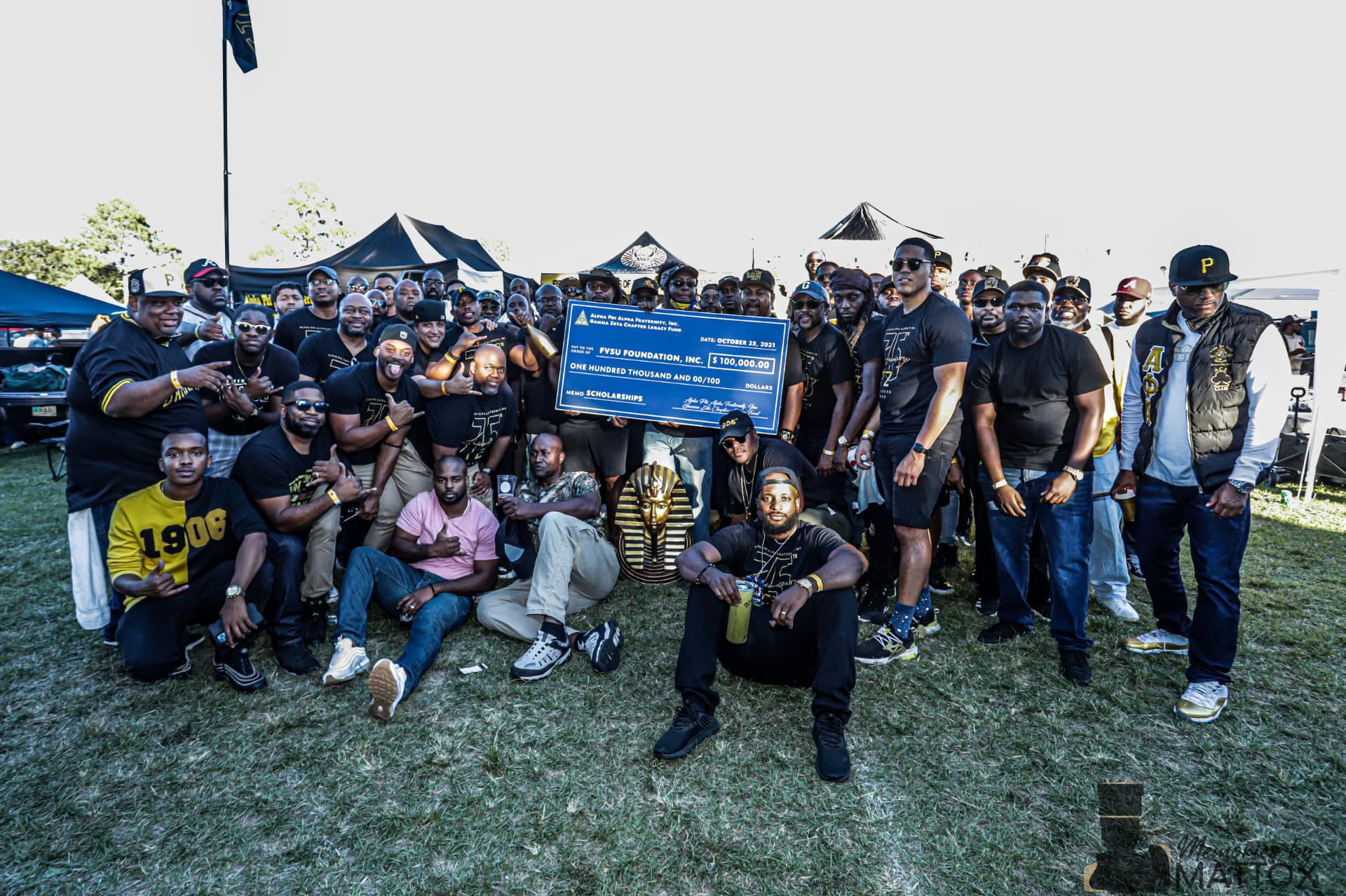 The brotherhood presenting a $100,000 scholarship check to the FVSU Foundation at the tailgate.