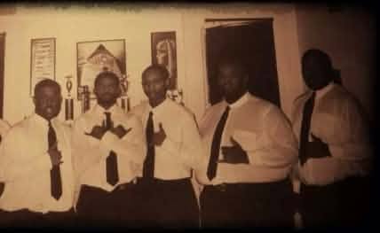 The Fall 1999 Phi 2 K line in a sepia-toned photo, five brothers in white dress shirts, ties, and dark slacks posed indoors.